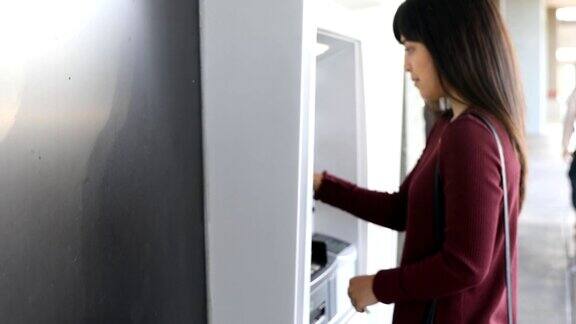 千禧一代半日本女性在银行使用ATM机