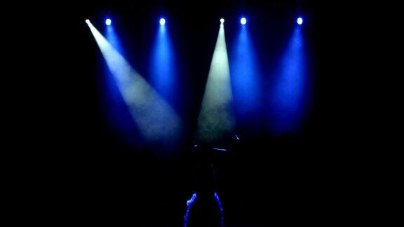 那位美丽的歌手在黑暗中在舞台上唱歌