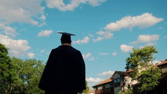 剪影日落大学毕业生的背影走在路上慢镜头特写镜头