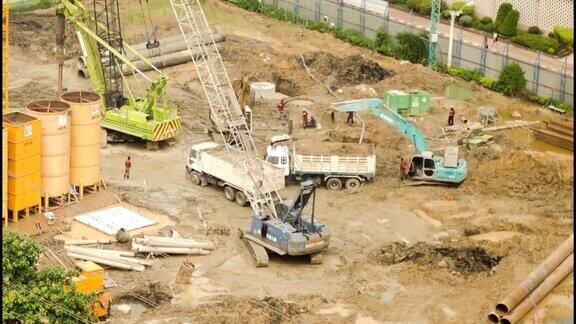 挖掘机、起重机和卡车正在施工现场工作