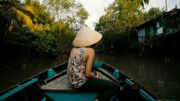一名妇女乘船穿过湄公河三角洲