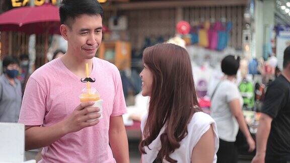 SLOMO一对年轻的亚洲夫妇在街头食品市场购物