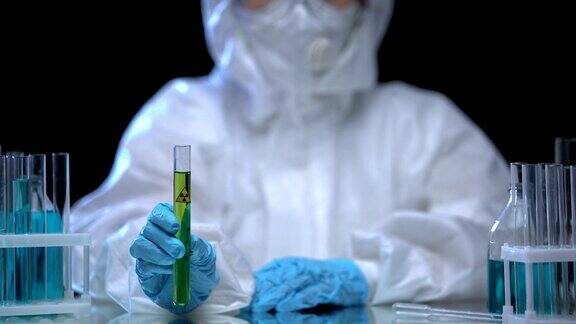 有毒实验室工作人员拿着装有绿色电离辐射液体的试管