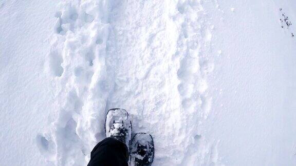 穿着雪鞋在野外白雪皑皑的小路上
