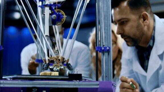 研究人员观察3d打印机器的运行过程