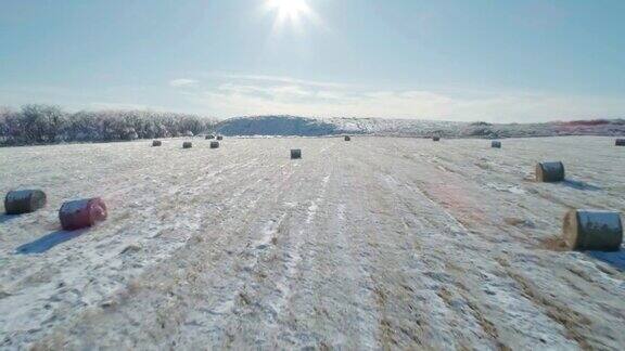 空中景观的干草覆盖着雪和冰冻的森林和山脉在冬季的背景镜头推进