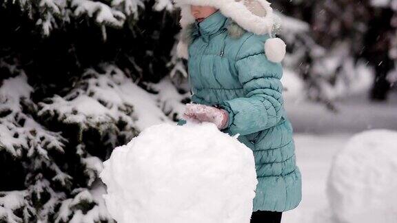 女孩冬天在雪地里堆雪人