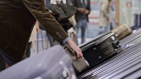 乘客从机场行李传送带上取下行李