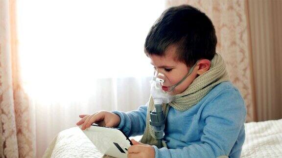 喷雾器用于吸入孩子用氧气面罩敷在脸上玩片剂生病的孩子通过喷雾器呼吸男孩做吸入在家治疗