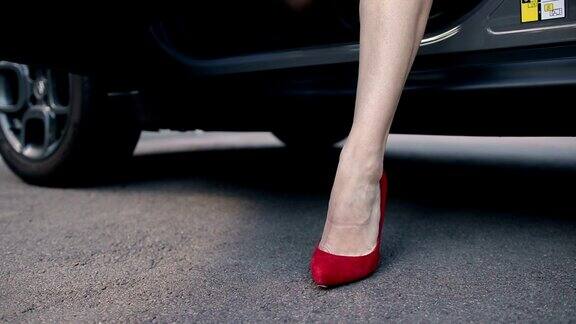 穿着红色高跟鞋的女人的腿从车里走出来
