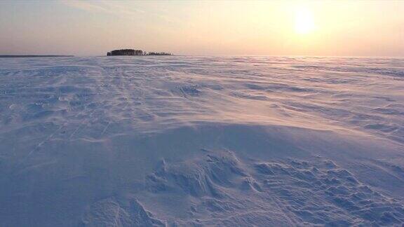 俄罗斯西伯利亚鄂毕河水库冬天日落时风和雪在冰冻的河流上