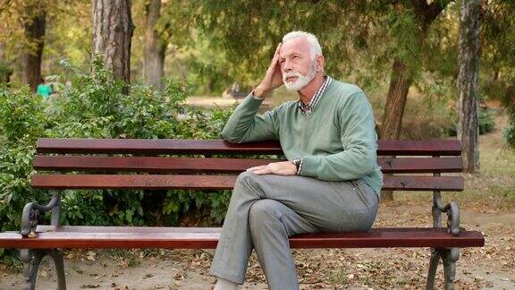 一个老人独自坐在公园的长椅上