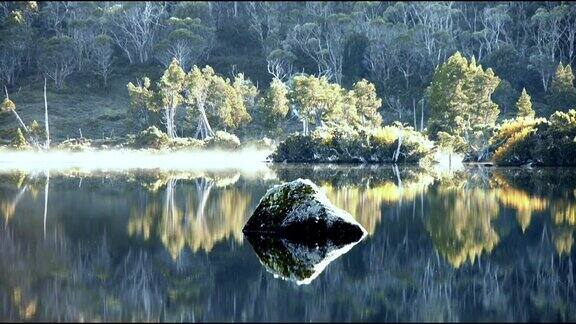 晨雾笼罩在平静的湖面上湖面上有岩石