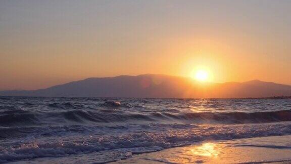 平静海面上令人惊叹的美丽日出黄色的太阳从海上和山上升起太阳的路径在水上阳光和太阳光反射在水面上金色的光橙色和金色的蓝天