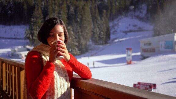 年轻女子在滑雪胜地享受热茶