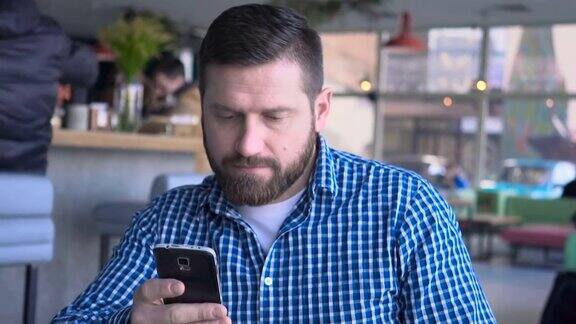 男子短信打字使用智能手机应用程序咖啡馆人像稳定器拍摄