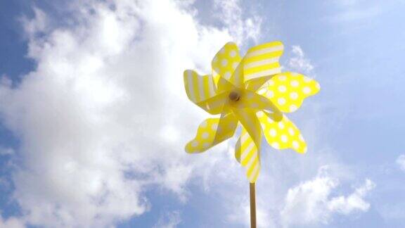蓝色的天空上黄色的风车在风中旋转夏天