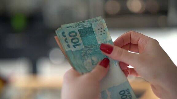 女人手里拿着一种巴西货币雷亚尔