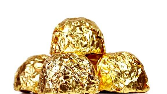 金箔包裹的巧克力糖果在白色背景上旋转