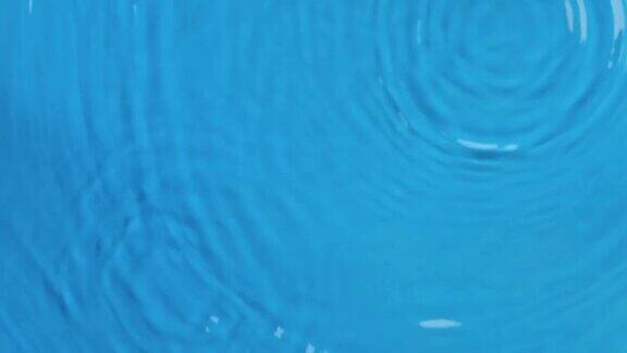 雨滴落在蓝色海水的波浪上前视图水滴落入水中