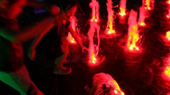 孩子们在发光的喷泉中玩耍