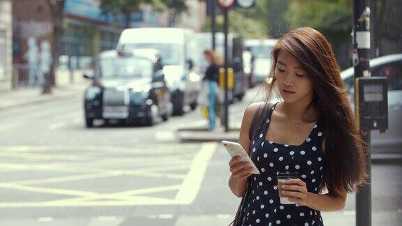 年轻的中国女子在伦敦等出租车(慢镜头)