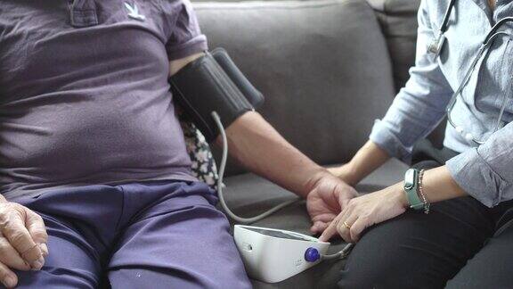 女医生检查一个资深亚洲男性病人的血压在家