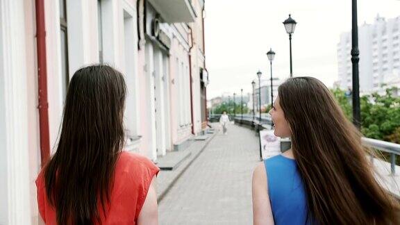 风吹着长长的黑发漂亮的年轻女子走在街上经过的商店后视镜慢悠悠地mostedicam拍摄