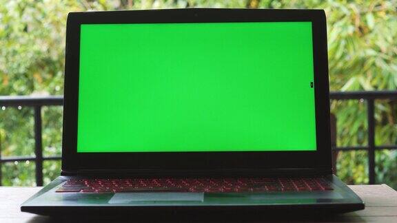 绿色屏幕的笔记本电脑放在桌子上关闭了