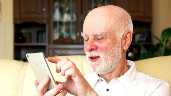 老人在家用手机浏览看新闻退休后活跃的现代生活