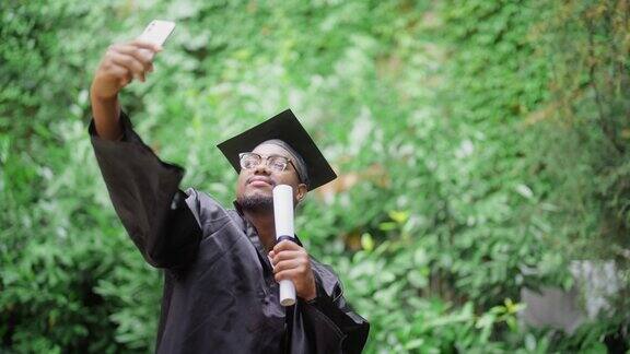 黑人学生在毕业典礼上用智能手机自拍