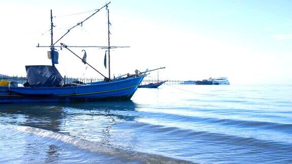 清晨的阳光下旧渔船停泊在海滩上