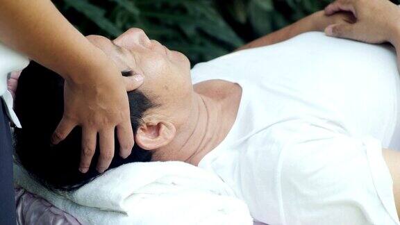 老人在户外做头部按摩亚洲男人躺在床上快乐的心情高级生活方式