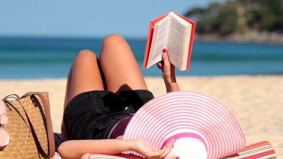 特写女孩在沙滩上看书放松