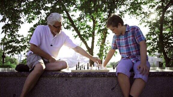 爷爷和孙子在公园里下棋慢镜头摄影车