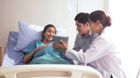 摄影:医生向怀孕的妻子和年轻的丈夫展示健康的结果