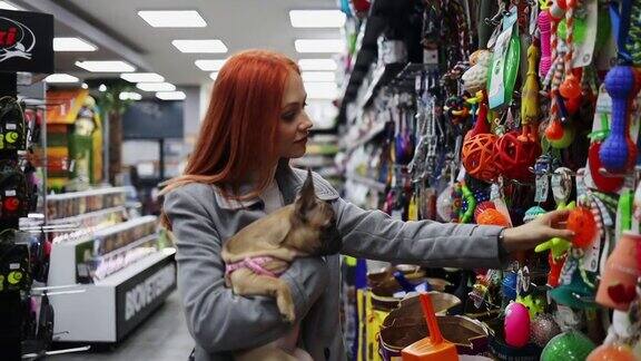 一个年轻的女人和她的狗在宠物店