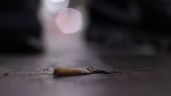 靠近地板上的香烟被脚踩碎