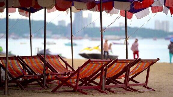 热带岛屿海滩上的天然沙滩和带遮阳伞的沙滩长椅绿松石海和蓝天景观的假日休闲暑期旅游概念