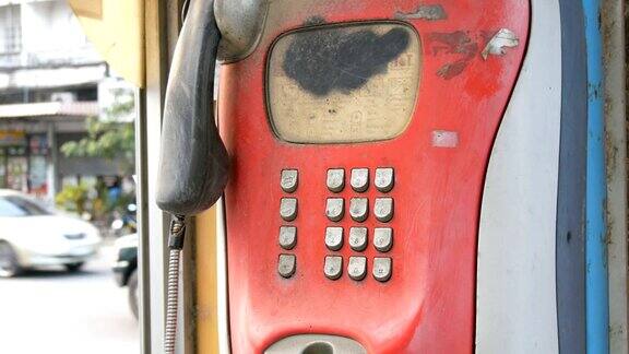 城市街道上的一台破旧的红色电话机电话亭里的老式电话
