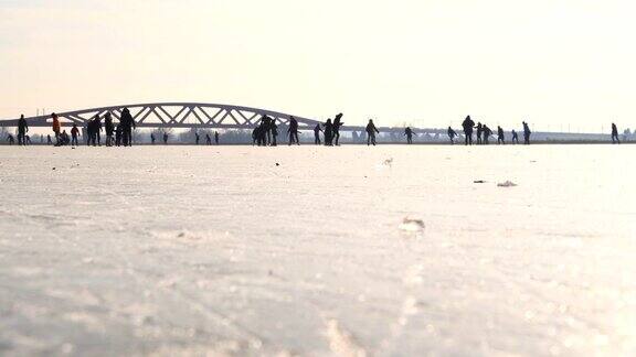 人们在荷兰IJssel河边结冰的湖面上滑冰