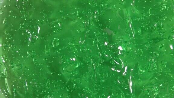 芦荟汁的运动绿色液体膏霜化妆品表面转动凝胶液带泡泡的美容护肤产品样品前视图慢动作