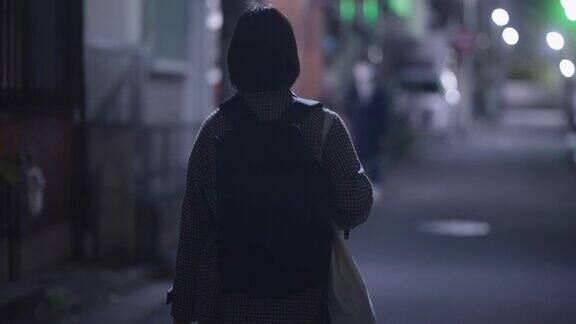 在冬天的晚上年轻女子戴着防护面罩走在街上