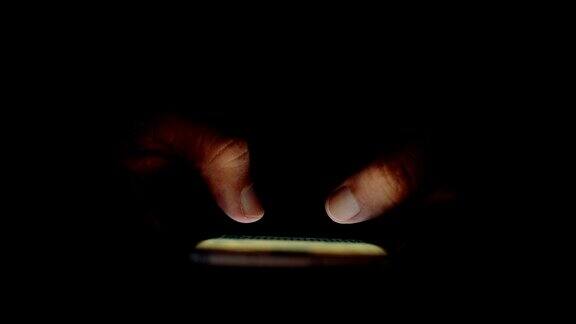 在黑暗中使用智能手机的特写