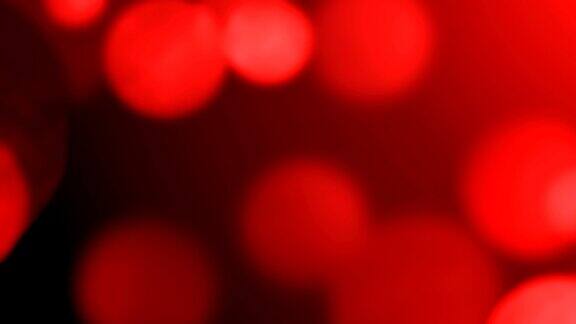 移动红色散景闪光灯散焦光反射可循环的4k背景视频概念的爱圣诞节派对社会活动庆祝活动生日活动