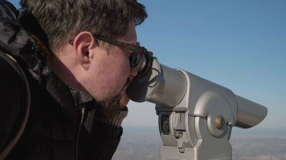 人类正在山上用旅游望远镜观看