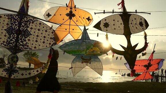 以传统风筝为前景的穆斯林孩子放风筝的剪影