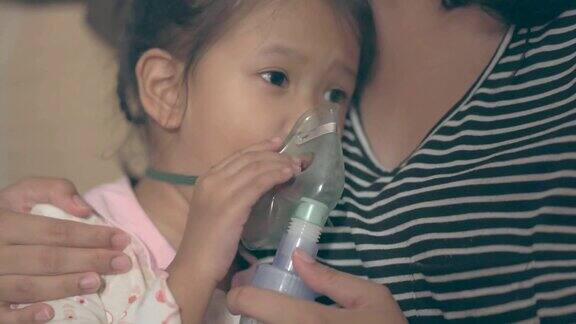 生病的亚洲女孩正在接受她母亲的喷雾器治疗