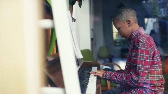 男孩在家弹钢琴的侧视图