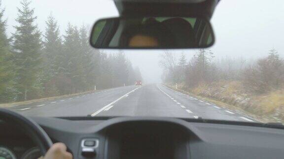 迎面而来的交通-驾驶在一个多雾的冬天的山路上-POV拍摄手持相机